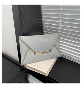 Macro detail van zilveren glitter clutch met elegante gouden metalen rand en envelopklep