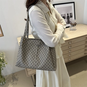 Borsa tote minimalista con motivo geometrico e borchie dorate in un ambiente domestico