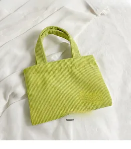 Détail du sac à bandoulière en velours côtelé vert citron avec poignées tissées sur tissu