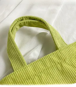 Gros plan sur la texture en velours côtelé vert clair de la sangle du sac à main