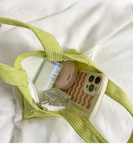 Gros plan du sac fourre-tout en velours côtelé vert clair avec intérieur spacieux