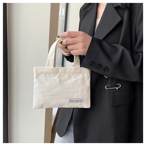 Détail du mini sac cabas en velours côtelé blanc cassé avec rayures et étiquette tissée