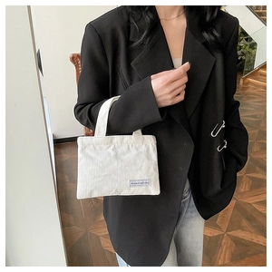 Détail du sac cabas en velours côtelé blanc avec texture verticale et étiquette tissée