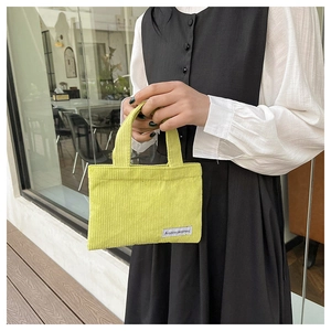 Détail d'un mini sac à main en velours côtelé vert avec étiquette tissée A GOGO ORIGINAL