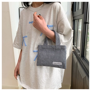 Gros plan d'un sac cabas en velours côtelé gris avec étiquette en tissu A GOGO ORIGINAL