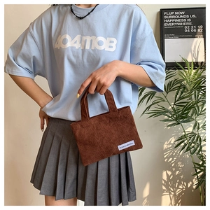 Détail du sac à main en velours côtelé marron avec anses et étiquette A GOGO ORIGINAL