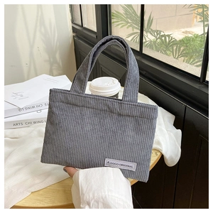 Vue détaillée de la texture velours côtelé gris et étiquette sur le sac à main