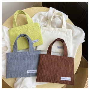 Vue à plat de quatre sacs cabas vintage en velours côtelé vert, beige, bleu et marron