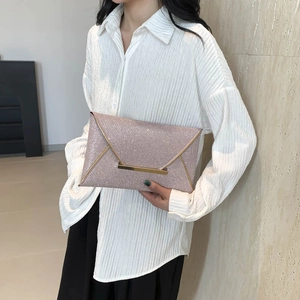Roségouden enveloppe clutch met pailletten en goudkleurige V-metalen rand vastgehouden door model