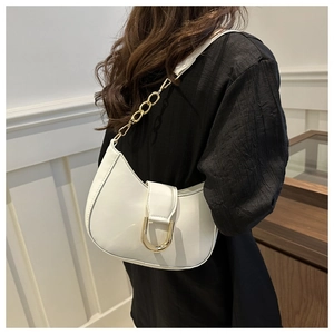 Detail of white crescent shoulder bag featuring gold D-buckle and elegant chain strap