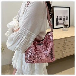 Detail der rosa Pailletten-Hobo-Tasche mit Fashion-Etikett und geknotetem Schultergurt
