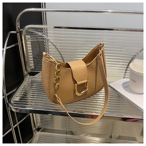 Detail of light brown crescent shoulder bag featuring a golden D-ring buckle and strap