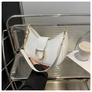 Detail of white semi-circle hobo bag featuring gold D-buckle and elegant chain strap