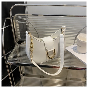 Detail of white PU leather baguette bag with gold D-buckle and chain decoration