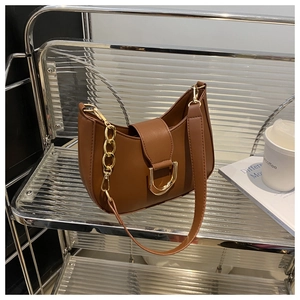 Detail of a brown Hobo shoulder bag with a gold horseshoe buckle and thick metal chain