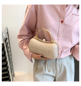 Dettaglio della pochette da sera champagne con chiusura in strass e catena dorata