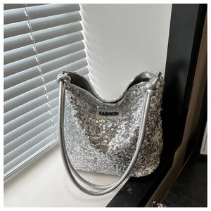Detailaufnahme der silbernen Pailletten-Beuteltasche mit Knotengriff und Fashion-Label