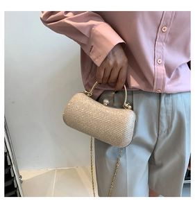 Detail of champagne gold glitter evening bag with metal handle and rhinestone clasp