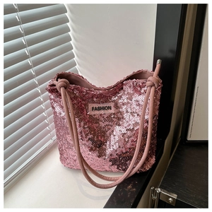 Detailaufnahme der rosa Pailletten-Tragetasche mit schwarzem Mode-Label und Tragegriffen