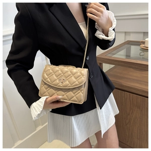 Dettaglio dell'elegante trama trapuntata beige e della chiusura a girello in metallo dorato