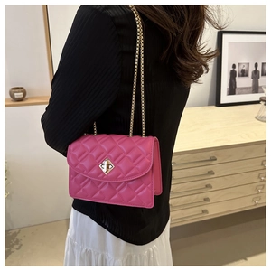 Dettaglio della borsa trapuntata rosa con chiusura a rotazione dorata e catena chic