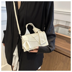 Detail of off-white geometric crossbody bag with decorative knotted handle and matte texture