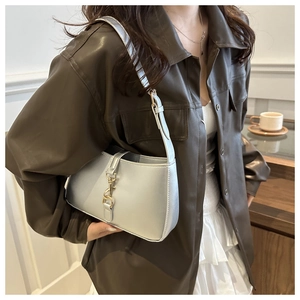 Silver metallic leather shoulder bag with gold clasp shown on a fashion model shirt