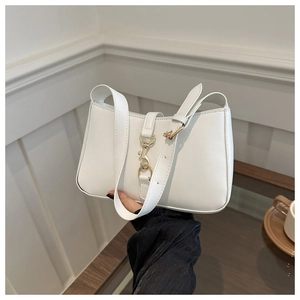 Detailed view of white faux leather shoulder bag featuring elegant gold metal clasp