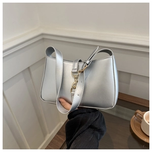 Detail of silver metallic underarm bag showing smooth PU leather texture and metal buckle
