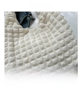 Detailed macro view of the cream white popcorn fabric texture and pleated material finish