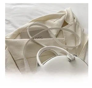 Detailed close-up of smooth white faux leather semi-round bag with silver metal hardware