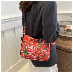 Detail of red floral tote bag showing vibrant peony patterns and fabric strap detail