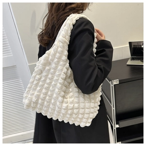 Detail of white puffer tote bag showing unique bubble pleated texture and large capacity