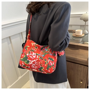 Floral print shoulder bag with traditional red peony patterns shown in a lifestyle setting