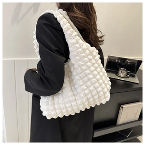 Detail of white popcorn textured tote bag showing 3D bubble fabric on a shoulder strap