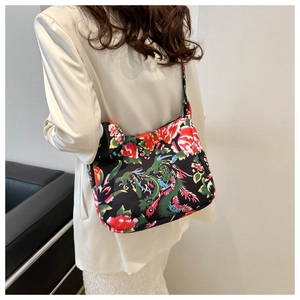 Floral shoulder bag with red flowers and green dragon patterns shown on a white blazer