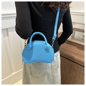 Sky blue crescent shoulder bag with smooth leather and adjustable strap on a model