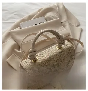 Detail of straw woven bag with floral embroidery, knotted handle, and romantic aesthetic