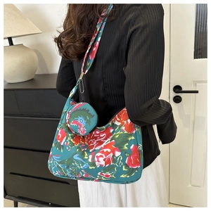 Close-up of hobo bag set with floral print and circular coin purse on a model