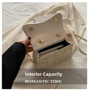 Detail view of woven straw crossbody bag interior with floral embroidery and magnetic closure