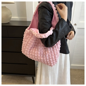 Detail showing the light pink popcorn fabric texture of the minimalist shoulder tote bag