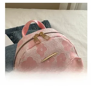 Detail of pink floral backpack showing smooth double metal zippers and embossed texture