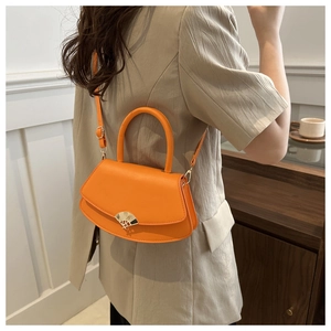 Modèle portant un sac besace orange vif montrant le style porté en bandoulière