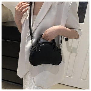 Detail of black matte shell bag showing smooth leather texture and silver hardware