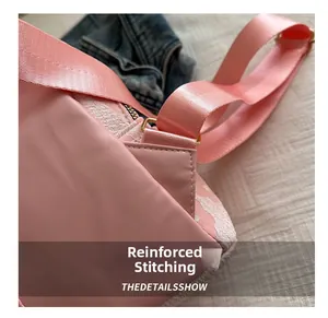 Close-up of pink backpack showing reinforced stitching on the shoulder strap connection