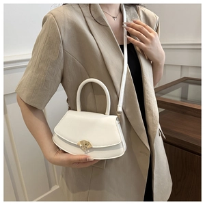 Gros plan d'un sac bandoulière blanc demi-lune avec un fermoir doré en forme d'éventail