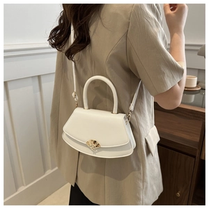 Détail d'un sac selle blanc semi-circulaire avec boucle éventail dorée sur un mannequin