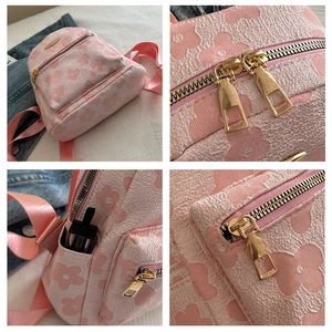 Detail of pink floral jacquard backpack with golden zippers and side storage pocket