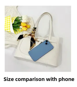 Detail of white crocodile embossed tote bag with scarf and smartphone for scale