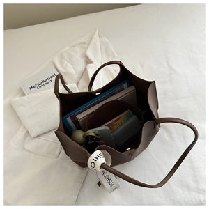 Brown tote bag interior showing large capacity with tablet, books and pouch